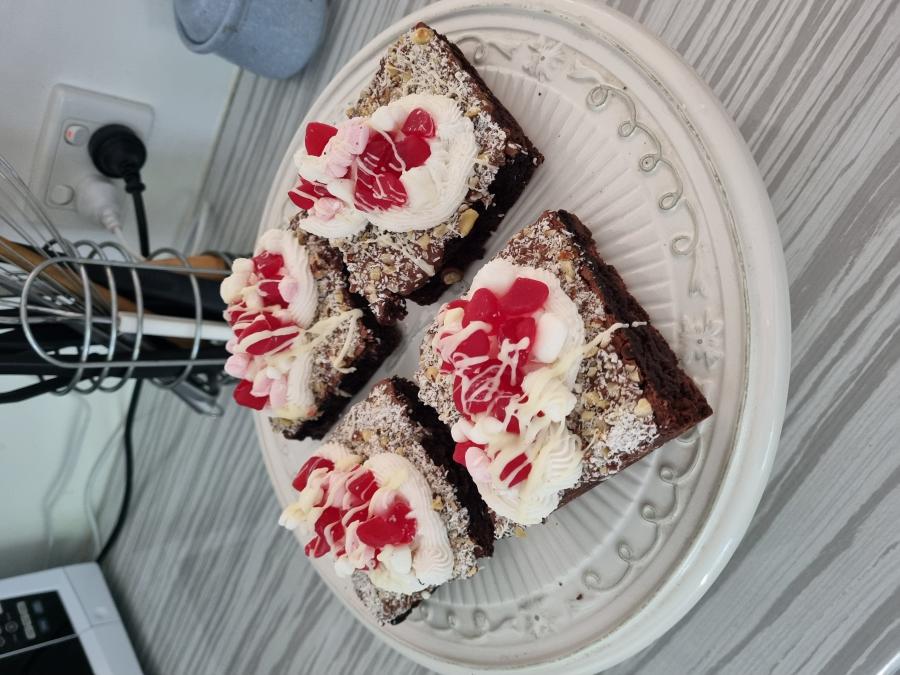 Chocolate brownie topped with vanilla buttercream, marshmallows, nuts, raspberry lollies and chocolate drizzle