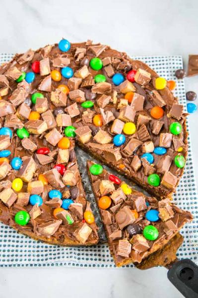 Chocolate chip cookie base topped with melted chocolate and an assortment of chocolates and lollies